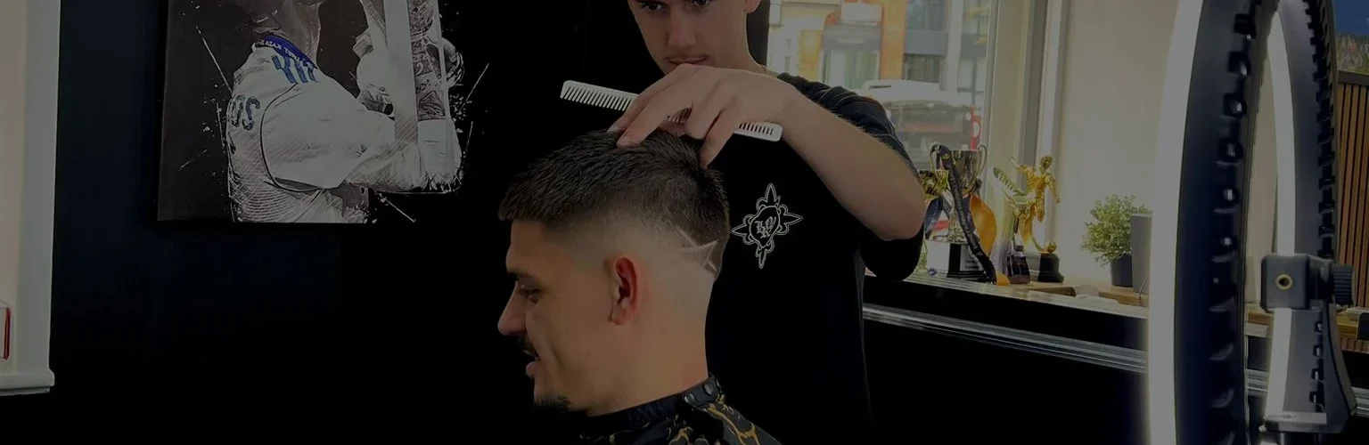 A TAHO BARBERS barber cutting a client's hair